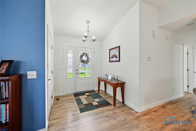 9274 Shaffer St, Findlay, OH 45840 - foyer entrance featuring a chandelier, light wood-style flooring, baseboards, and lofted ceiling