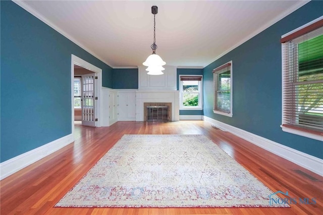 1211 S Main St, Findlay, OH 45840 - unfurnished living room featuring plenty of natural light, crown molding, wood finished floors, and baseboards