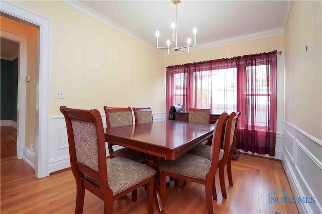 1211 S Main St, Findlay, OH 45840 - dining room with crown molding, a chandelier, wainscoting, a decorative wall, and light wood-type flooring