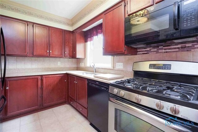 1211 S Main St, Findlay, OH 45840 - kitchen with black appliances, a sink, light countertops, and reddish brown cabinets