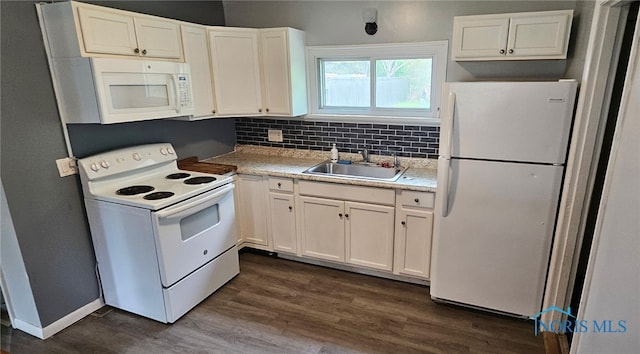 kitchen with white appliances, a sink, white cabinets, and dark wood-style floors