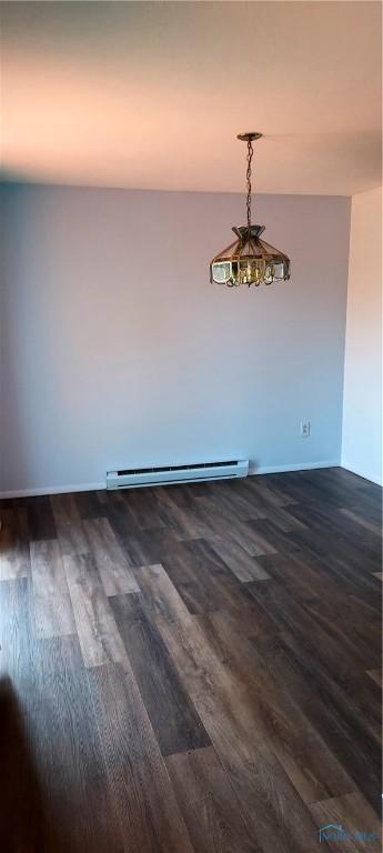 856 Village Pkwy, Waterville, OH 43566 - spare room featuring a baseboard heating unit, dark wood-type flooring, and baseboards