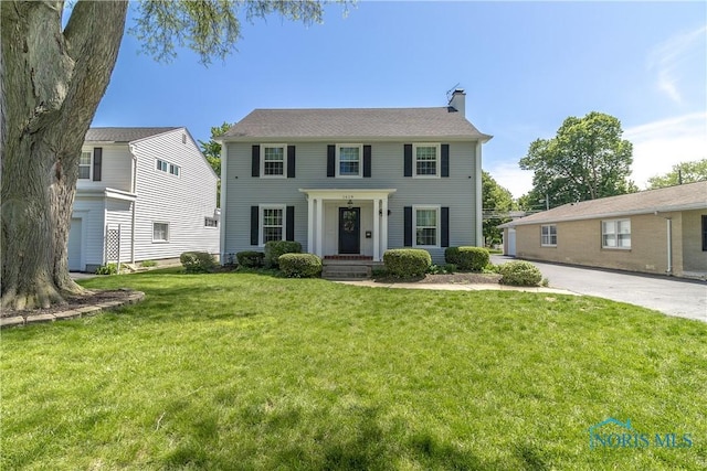 1619 Grant Blvd, Findlay, OH 45840 - colonial-style house featuring a chimney and a front lawn
