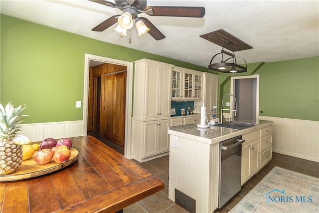 1619 Grant Blvd, Findlay, OH 45840 - kitchen featuring stainless steel dishwasher, a wainscoted wall, white cabinets, a sink, and dark tile patterned floors