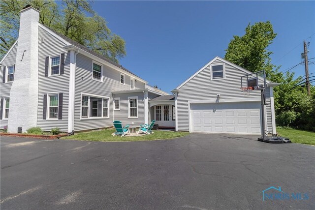 1619 Grant Blvd, Findlay, OH 45840 - view of front of house with a chimney, driveway, and an attached garage