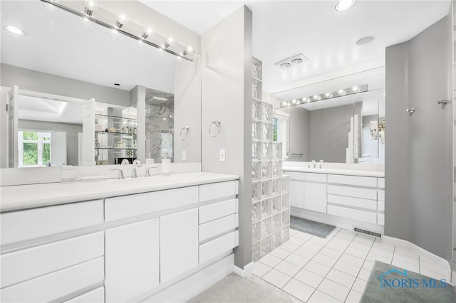 bathroom with walk in shower, two vanities, and recessed lighting