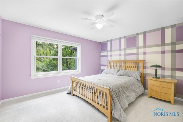 carpeted bedroom featuring baseboards, wallpapered walls, and ceiling fan