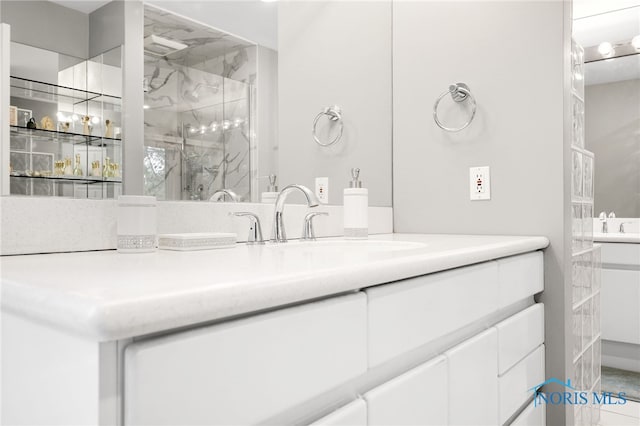 full bathroom featuring a marble finish shower and vanity