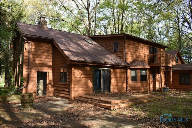 6044 County Road 2, Swanton, OH 43558 - back of house with a chimney, roof with shingles, a balcony, and central AC