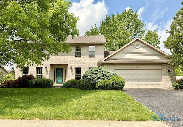 312 Fairmont Dr, Findlay, OH 45840 - colonial home with brick siding, asphalt driveway, a garage, and a front lawn