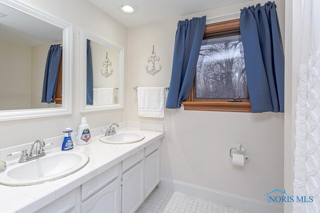 3757 N Mccord Rd, Toledo, OH 43617 - full bath featuring tile patterned flooring, double vanity, and baseboards
