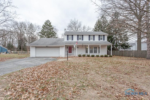 3757 N Mccord Rd, Toledo, OH 43617 - traditional home with fence, asphalt driveway, an attached garage, covered porch, and a chimney