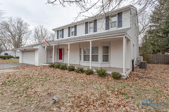 3757 N Mccord Rd, Toledo, OH 43617 - view of front of house featuring brick siding, an attached garage, a porch, central air condition unit, and fence