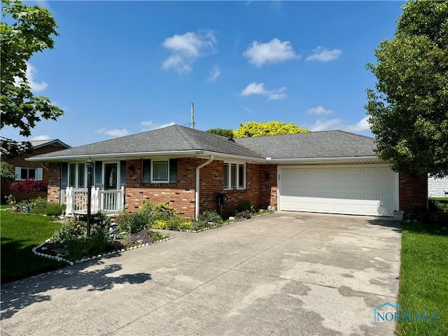 360 N Harmony Dr, Napoleon, OH 43545 - single story home featuring an attached garage, brick siding, concrete driveway, a front yard, and a porch