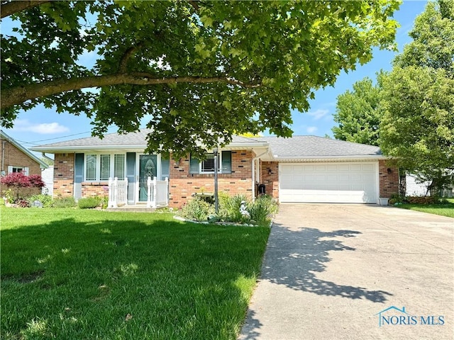 360 N Harmony Dr, Napoleon, OH 43545 - view of front facade featuring an attached garage, driveway, a front yard, and brick siding