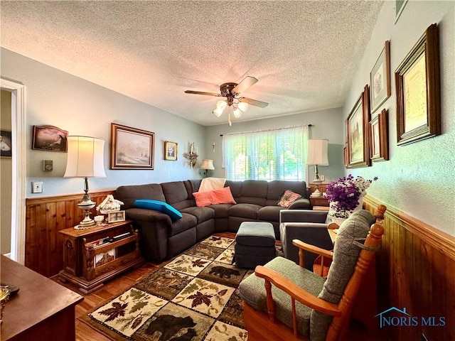 360 N Harmony Dr, Napoleon, OH 43545 - living room featuring wood finished floors, a ceiling fan, a textured ceiling, wainscoting, and wooden walls