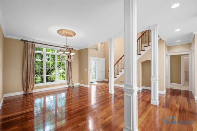665 Meadowview Dr, Findlay, OH 45840 - unfurnished living room with ornamental molding, wood finished floors, a chandelier, stairs, and baseboards