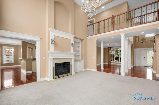 665 Meadowview Dr, Findlay, OH 45840 - unfurnished living room featuring a chandelier, carpet floors, ornate columns, healthy amount of natural light, and a towering ceiling