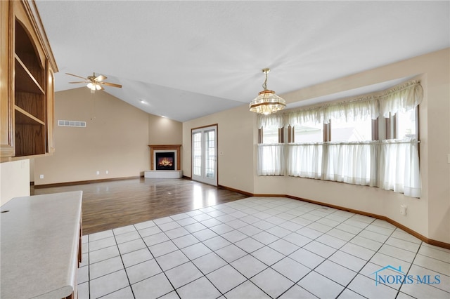 1330 Kennsington Dr, Findlay, OH 45840 - unfurnished living room with a chandelier, ceiling fan, a lit fireplace, baseboards, and light tile patterned flooring
