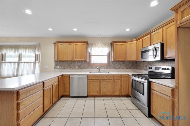 1330 Kennsington Dr, Findlay, OH 45840 - kitchen with stainless steel appliances, a peninsula, light countertops, tasteful backsplash, and a sink
