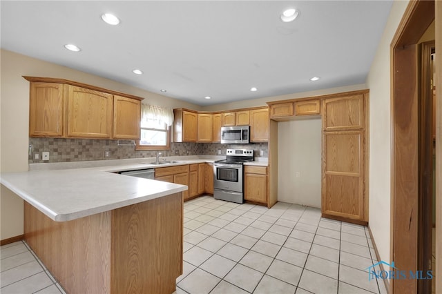 1330 Kennsington Dr, Findlay, OH 45840 - kitchen featuring appliances with stainless steel finishes, a peninsula, tasteful backsplash, light countertops, and a sink