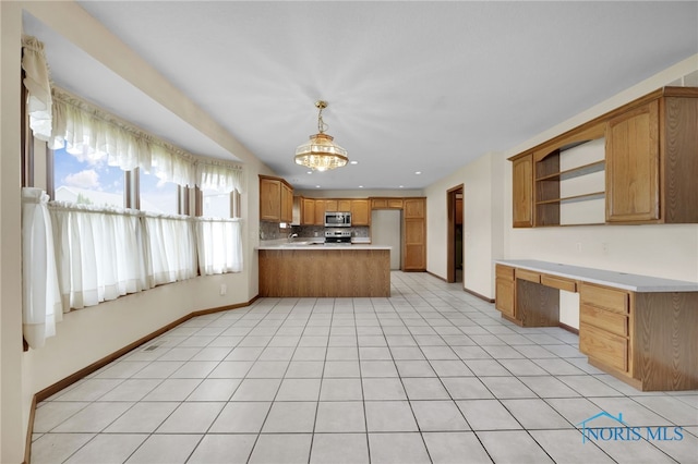 1330 Kennsington Dr, Findlay, OH 45840 - kitchen with stainless steel appliances, a peninsula, brown cabinets, light countertops, and baseboards