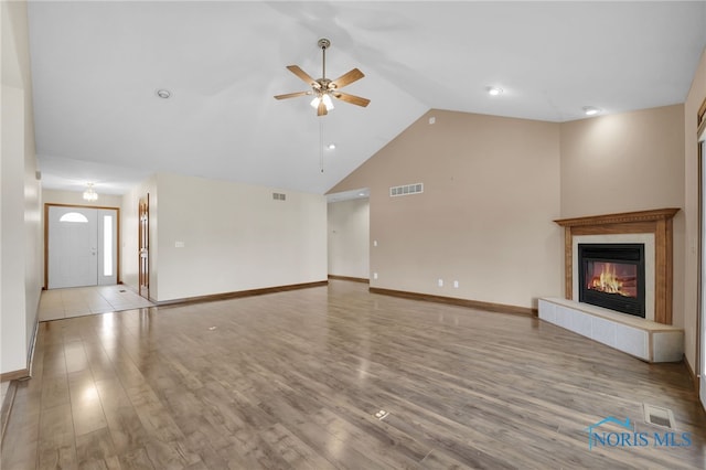 1330 Kennsington Dr, Findlay, OH 45840 - unfurnished living room featuring lofted ceiling, ceiling fan, wood finished floors, baseboards, and a tile fireplace