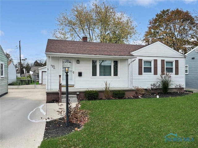 1381 Junior Dr, Maumee, OH 43537 - view of front facade with a front yard, a chimney, a shingled roof, and concrete driveway