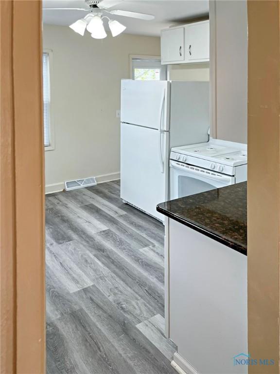 1381 Junior Dr, Maumee, OH 43537 - kitchen featuring white appliances, white cabinets, a ceiling fan, and wood finished floors