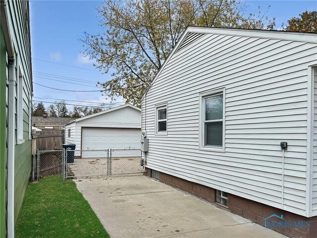 1381 Junior Dr, Maumee, OH 43537 - view of home's exterior featuring a garage, fence, and an outbuilding