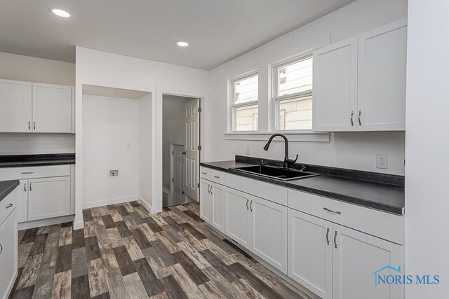 940 Kingston Ave, Toledo, OH 43605 - kitchen with a sink, dark countertops, white cabinets, dark wood-style floors, and recessed lighting