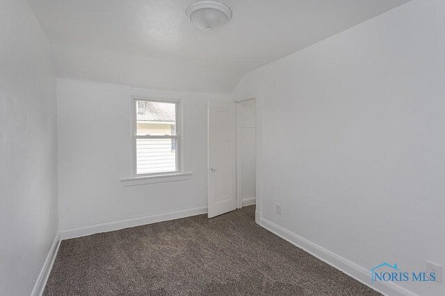 940 Kingston Ave, Toledo, OH 43605 - spare room with dark carpet, vaulted ceiling, and baseboards