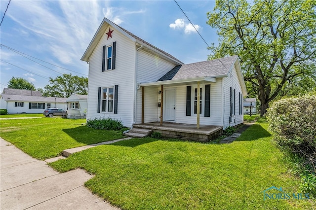 221 Poplar St, North Baltimore, OH 45872 - traditional-style house with a porch, a front lawn, and roof with shingles