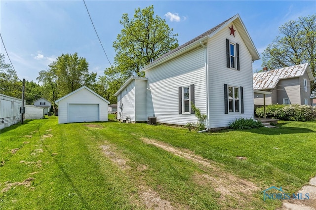 221 Poplar St, North Baltimore, OH 45872 - rear view of property featuring an outdoor structure, a garage, central air condition unit, and a yard