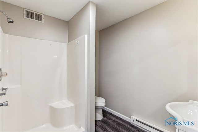 221 Poplar St, North Baltimore, OH 45872 - full bath with baseboard heating, a shower, wood finished floors, toilet, and baseboards