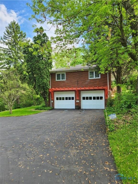 28330 W River Rd, Perrysburg, OH 43551 - view of front of home with driveway, an attached garage, and brick siding