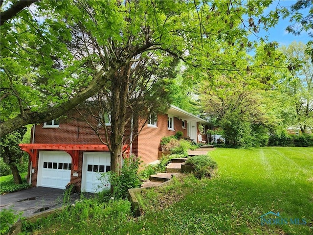 28330 W River Rd, Perrysburg, OH 43551 - view of side of property with brick siding, an attached garage, a yard, and driveway