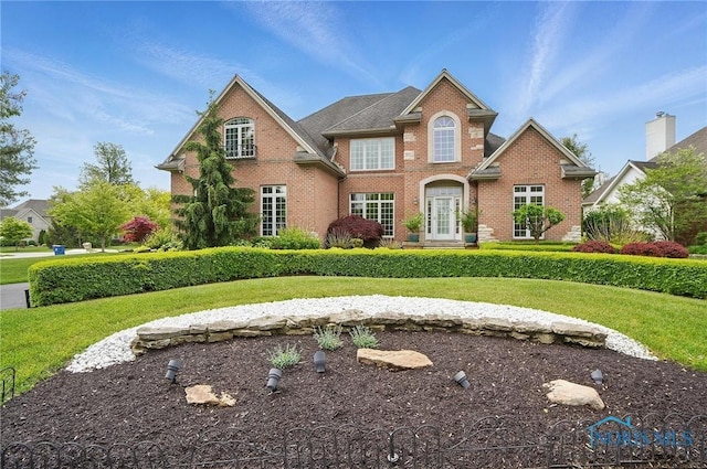 view of front of home with brick siding and a front yard
