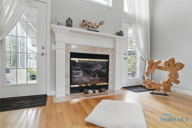 living area featuring a fireplace, wood finished floors, and baseboards