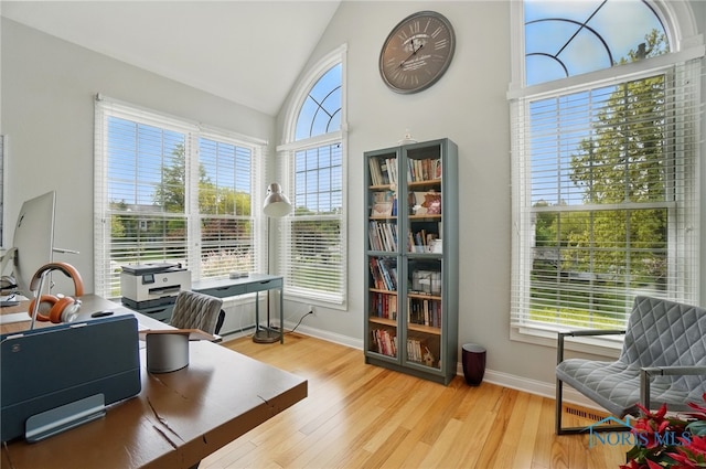 office with wood finished floors, high vaulted ceiling, and baseboards