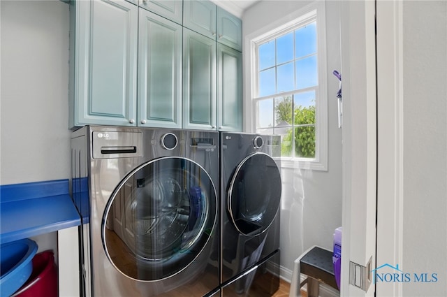laundry room featuring cabinet space, washer and dryer, and baseboards