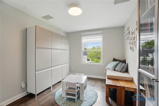 living area with dark wood-style flooring and baseboards