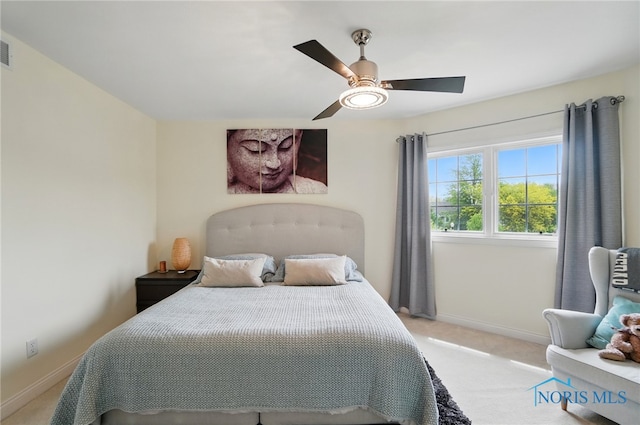 bedroom featuring light colored carpet, baseboards, and ceiling fan