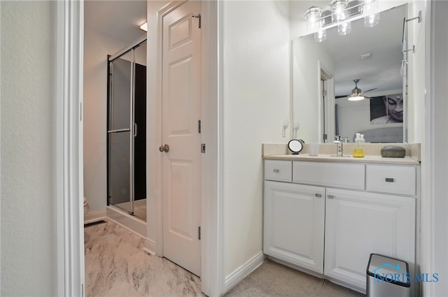bathroom featuring a shower stall, marble look tiles, ceiling fan, baseboards, and vanity