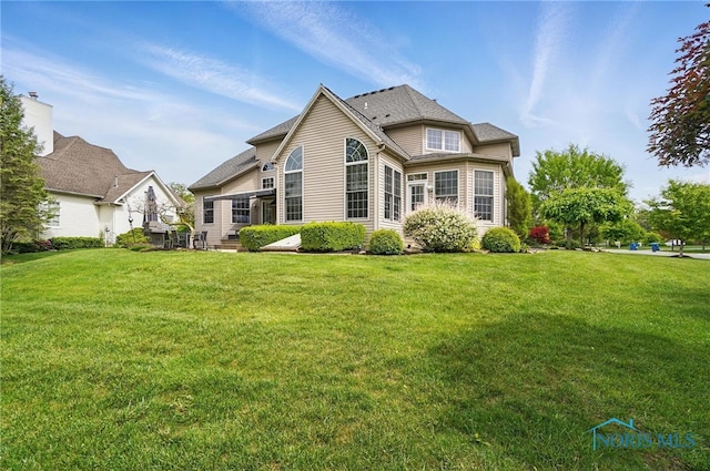 back of property featuring a yard