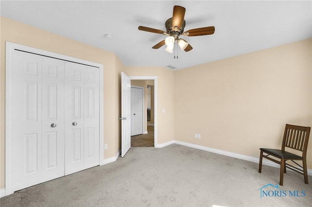 unfurnished bedroom with carpet floors, baseboards, a closet, and ceiling fan