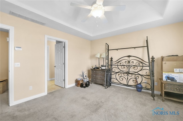 bedroom with carpet flooring, a raised ceiling, and baseboards