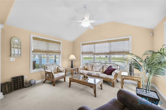 living room with carpet, a ceiling fan, vaulted ceiling, and baseboards