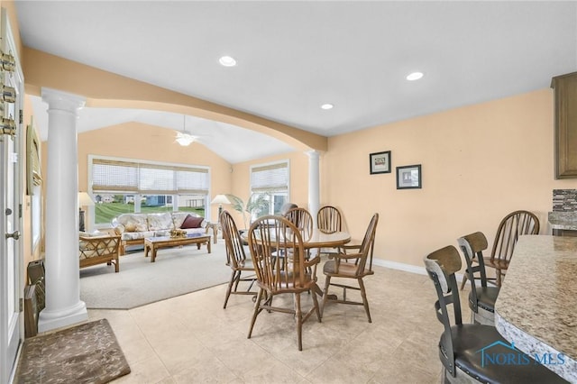 dining room featuring decorative columns, arched walkways, a ceiling fan, vaulted ceiling, and light carpet
