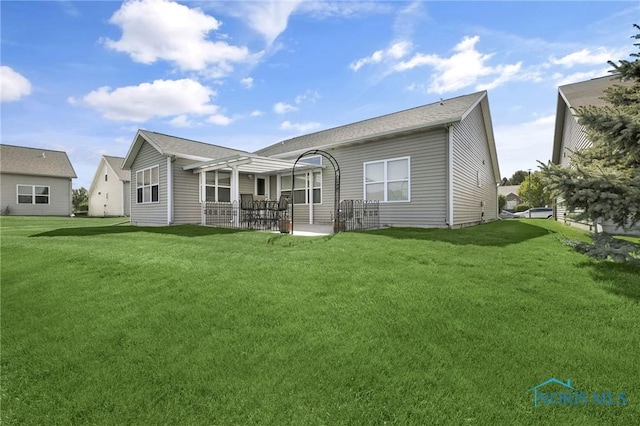 back of property featuring a patio, a yard, and a pergola